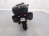 a black motorcycle parked in a room with a license plate on the back of it