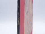a pink book with a black cover on a white surface