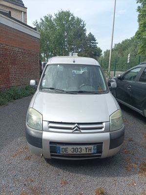 a small car parked in a parking lot next to a brick building