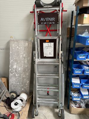 une échelle posée à côté d'une pile de cartons