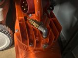 un souffleur orange posé par terre à côté d'une assiette blanche