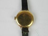 a close up of a watch on a white surface with a black strap