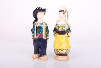 two figurines of a man and a woman standing next to each other
