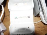 a white cell phone sitting on top of a table next to a keyboard