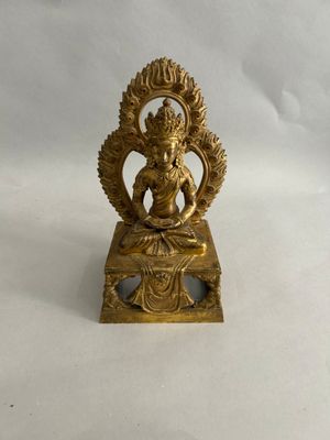 an image of a gold statue of a woman sitting on a table