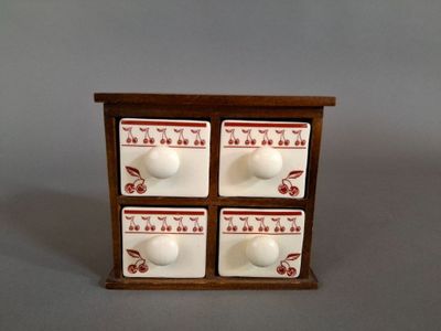 une petite boîte en bois munie de quatre tiroirs et de boutons