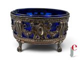 an antique silver and blue glass bowl sitting on a stand