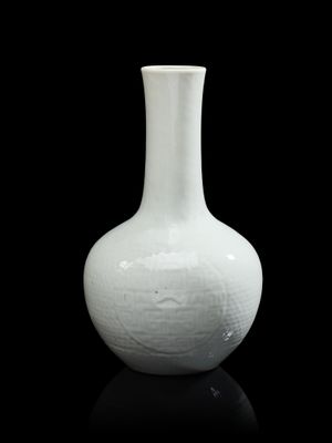 un vase blanc posé sur une surface noire