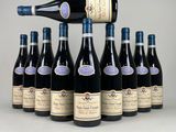 Des bouteilles de vin sont alignées sur une table, avec une bouteille de vin au milieu.