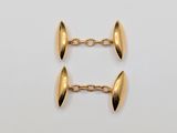a pair of gold plated cufflinks on a white background