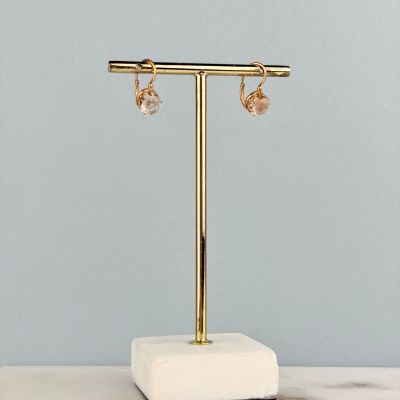 a close up of a pair of earrings on a stand on a table