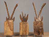 three pieces of wood that have been carved into the shape of antelope ' s heads