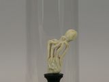 a small figurine in a glass clochet on a black base