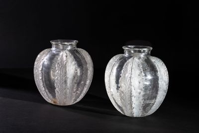 two glass vases that are sitting on a black surface