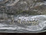 a statue of a man sitting on a rock with a name written on it