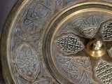 a metal plate with a design on it on a table