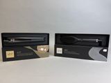 two black hair straightens in a box on a white surface