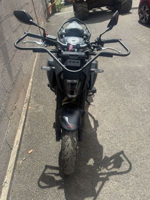 une moto noire garée sur le bord de la rue