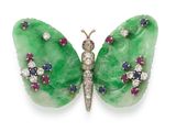 une image représentant une broche en forme de papillon vert, sertie de diamants et de rubis