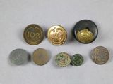 several coins and buttons are arranged on a white surface