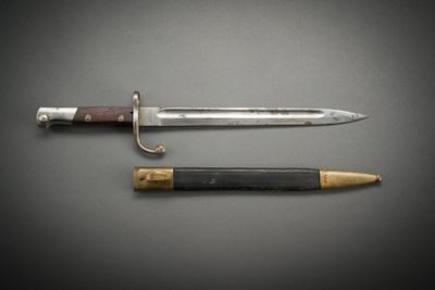 an old knife and a pencil sitting on top of a table
