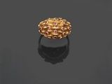une bague en or posée sur une surface noire, avec un reflet sur cette surface