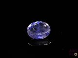 a close up of a blue sapphire stone on a black surface