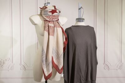une robe et un foulard sur un mannequin devant un mur blanc
