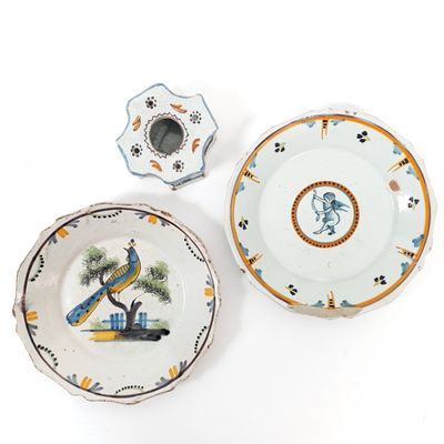 two plates and a candle holder are sitting on a white surface