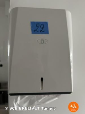 a paper towel dispenser with a blue sticker on it