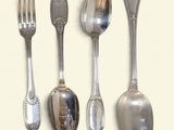 four spoons and a fork on a white surface