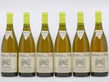 six bouteilles de vin sont alignées sur une surface blanche