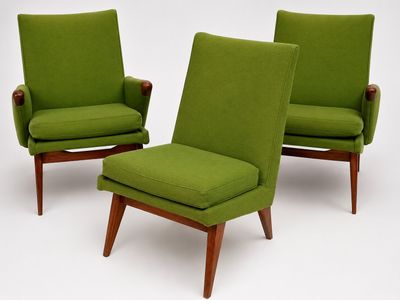 two green chairs and a foot stool in a white room
