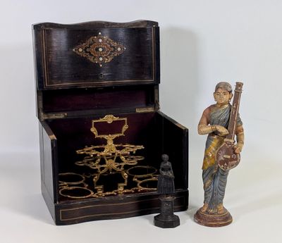 une figurine représentant un homme tenant un instrument de musique à côté d'une boîte