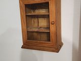 une petite armoire en bois contenant un oiseau
