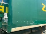 a green semi truck that is parked on the side of the road