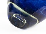 a close up of a blue glass object on a white surface