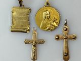three gold crosses and a gold medal on a white surface