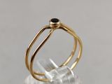 a close up of a gold ring with a black stone on it