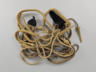 un tas de cordes et une paire de chaussures posés sur une surface blanche
