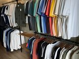 a lot of shirts hanging on a rack in a store