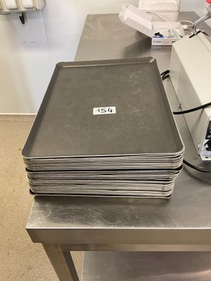 une pile de plateaux métalliques posée sur une table métallique