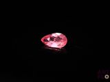 a close up of a pink diamond on a black surface