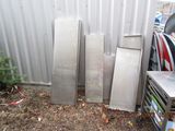 several pieces of metal are stacked up against a metal wall