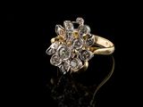 a close up of a gold and diamond ring on a black surface