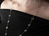 the woman is wearing a black top and a gold chain necklace