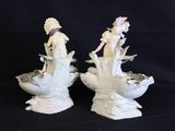 two figurines that are sitting on a black surface