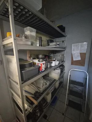 a kitchen with a lot of shelves and pots and pans on it