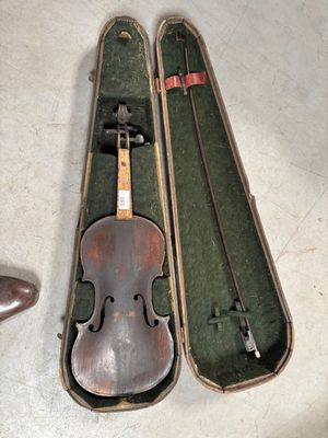 un violon dans son étui, à côté d'une paire de chaussures