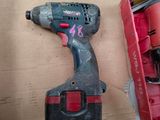 a cordless drill and a box of tools on a table